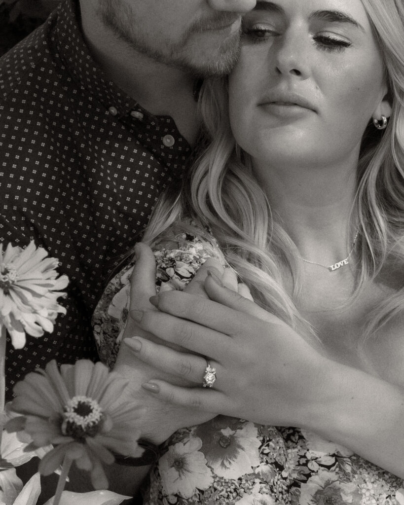 Couple sitting in flowers for engagement photos
