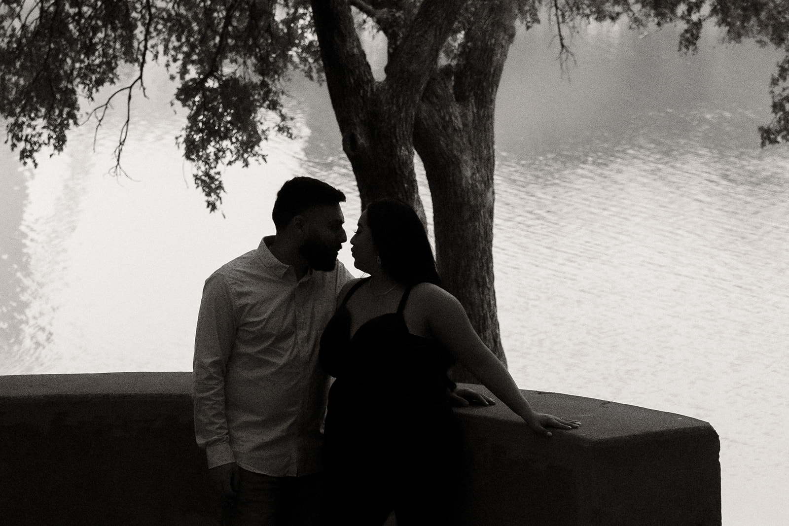 Engaged couple under tree next to a river