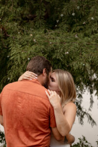 Couple kissing by a river for Waco engagement session