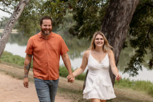 Couple walking by a river for Waco engagement session