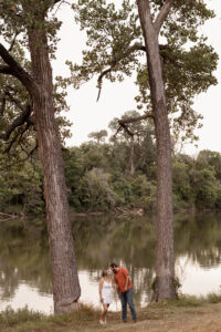 Couple kissing by a river for Waco engagement session