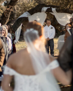 Groom watching bride walk down the aisle