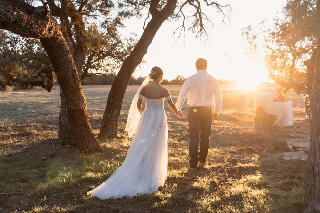 Bride and groom walking into sunset after ceremony