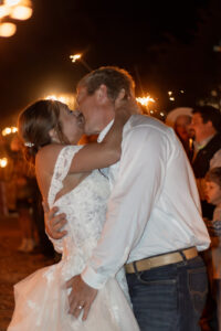 Bride and groom kissing at sparkler exit