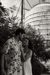 Couple smiling at each other after proposal in front of Magnolia silos