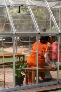 Couple kissing in a greenhouse for an engagement photoshoot