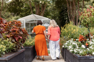 Couple walking in a flower garden for an engagement photoshoot