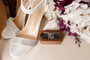 Flatlay with bridal shoes, rings, and bouquet