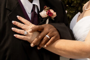 Bride and groom holding hands to show their wedding bands