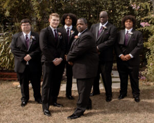 Groomsmen and groom photo pose at outdoor wedding