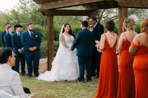 Bride and groom holding hands at outdoor wedding ceremony