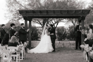 Bride and groom first kiss at outdoor wedding ceremony