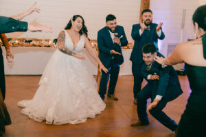 Guests and bride and groom dancing at reception