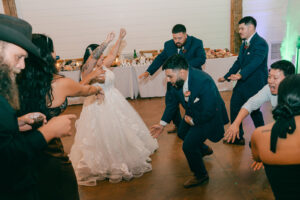 Guests and bride and groom dancing at reception