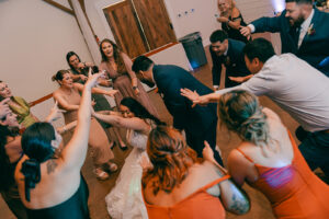 Guests and bride and groom dancing at reception