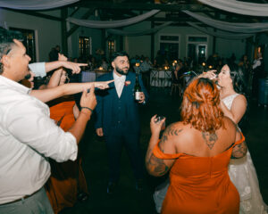 Guests and bride and groom dancing at reception