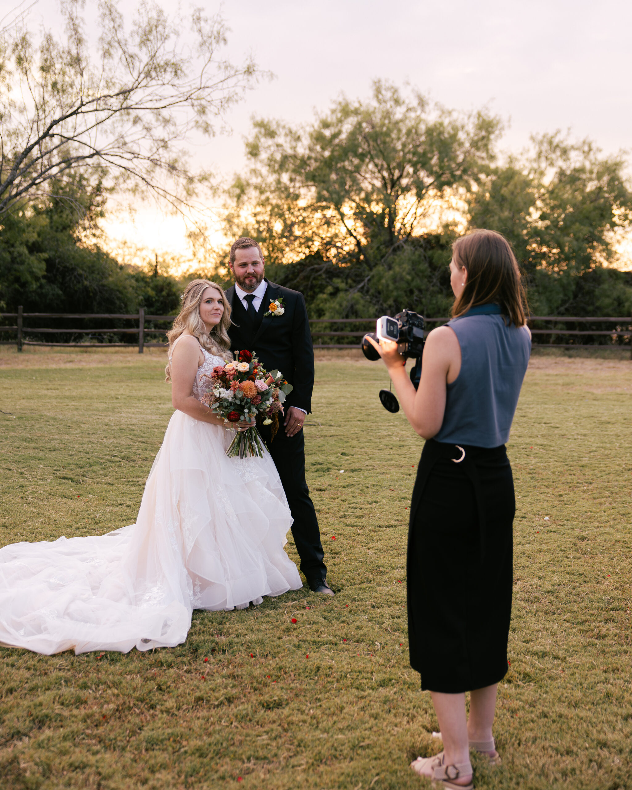 Wedding photographer taking photos of the bride and groom sunset portraits