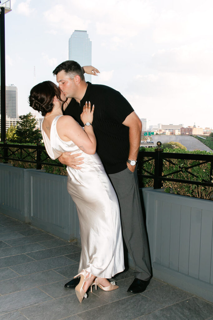 Couple kisses at bar for engagement photos