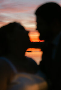 Ashley + Ethan Bride and groom silhouette against a lake sunset