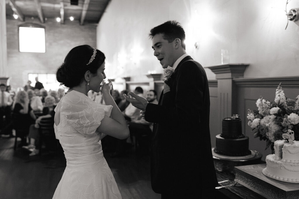 Bride and groom cut wedding cake during reception