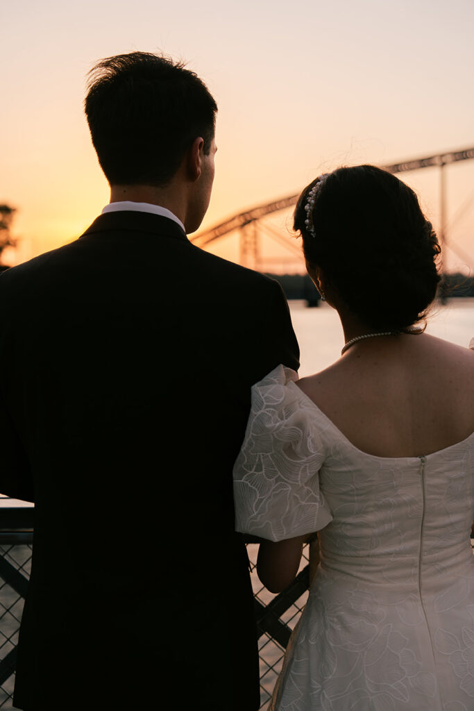 Bride and groom at suspension bridge during sunset bridal portraits after wedding