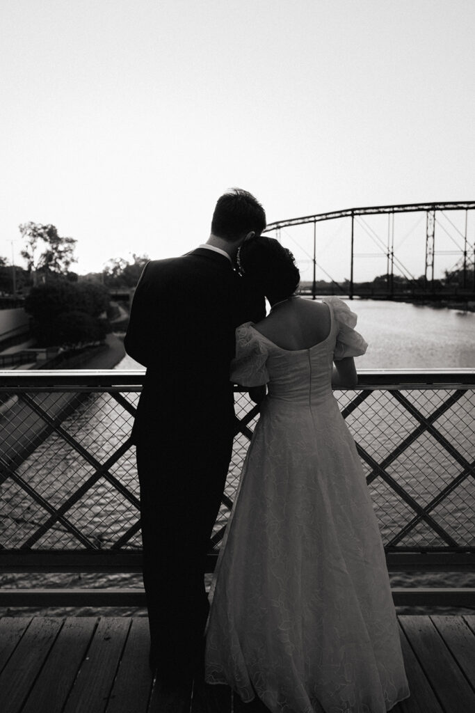 Bride and groom at suspension bridge during sunset bridal portraits after wedding