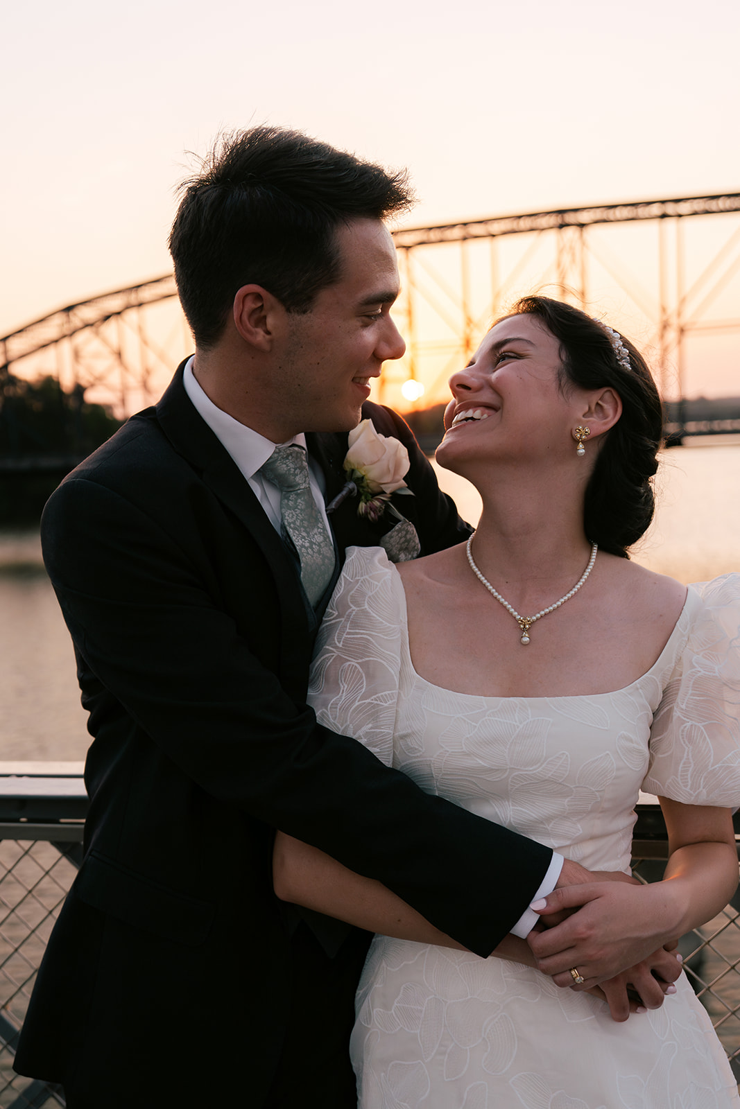 Bride and groom at suspension bridge during sunset bridal portraits after wedding